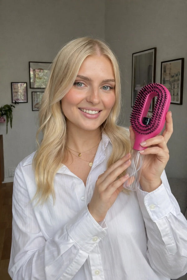 Cliente StyraHair tenant la brosse Styra Magic rose